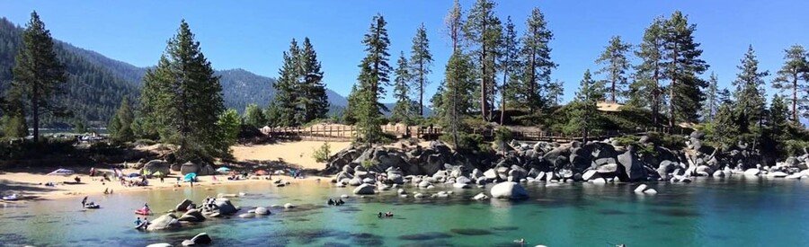sand harbor beach with swimmers and granite boulders in clear lake tahoe water