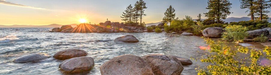 sunset over sand harbor with granite boulders and glowing lake tahoe water