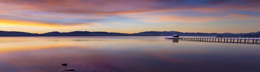 sunrise over lake tahoe with calm water and distant mountain views