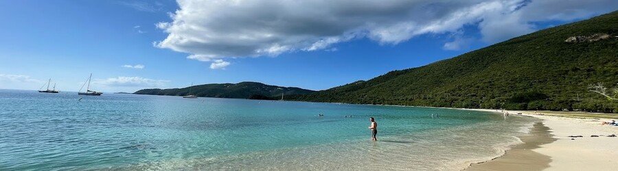 Brewers Bay in Tortola with calm turquoise water, soft sand, and green hills surrounding the quiet beach.