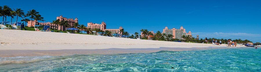 Crystal-clear turquoise water rolling onto the white sand of Cabbage Beach on Paradise Island.