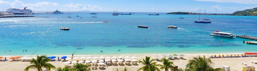 Great Bay Beach in Philipsburg St. Maarten with calm turquoise water and boats offshore