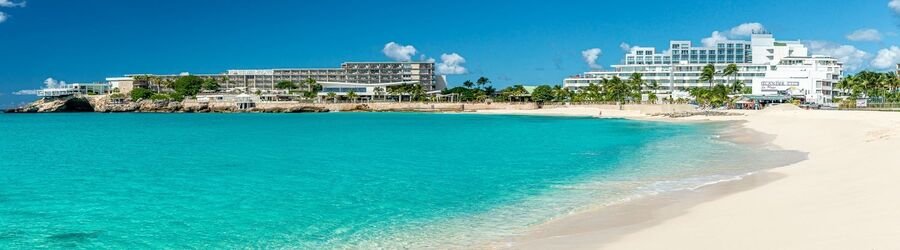 Maho Beach St. Maarten with turquoise water and beachfront resorts on a sunny day