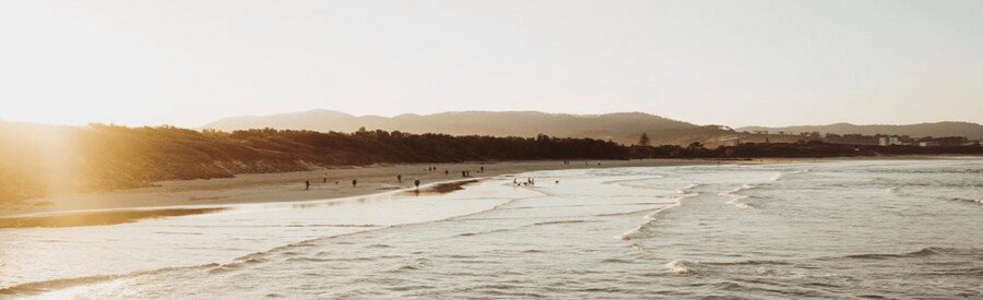 Soft sunset light over Sapphire Beach in St. Thomas, with gentle waves and distant hills along the shoreline.