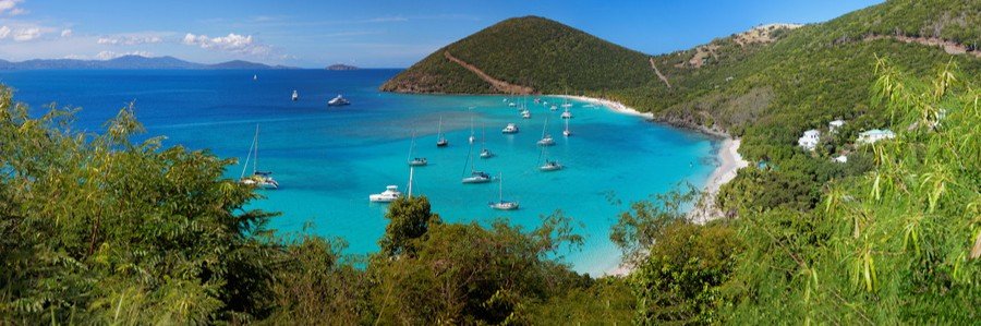 Brewers Bay with turquoise water, anchored sailboats, and green hills