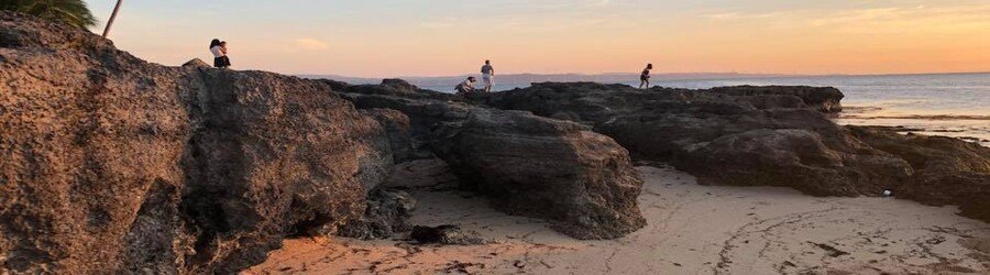 Saud Beach sunset in Pagudpud Ilocos Norte with rocky shoreline and calm sea