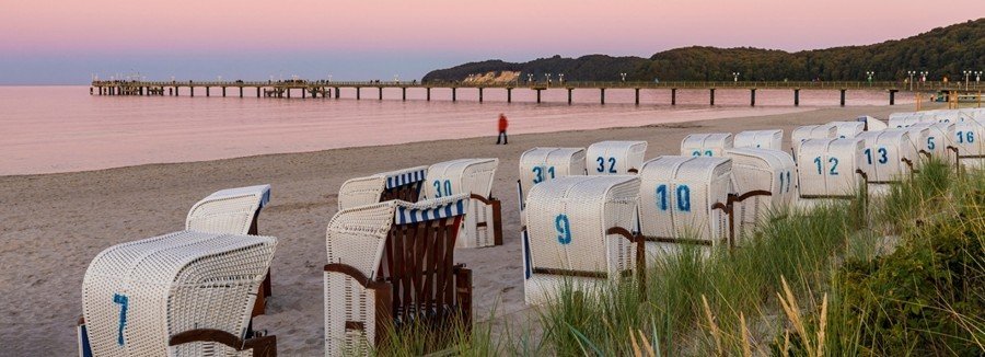 Strandkörbe beach baskets on Binz Beach Rügen Island Germany with Baltic Sea shoreline and pier at sunset