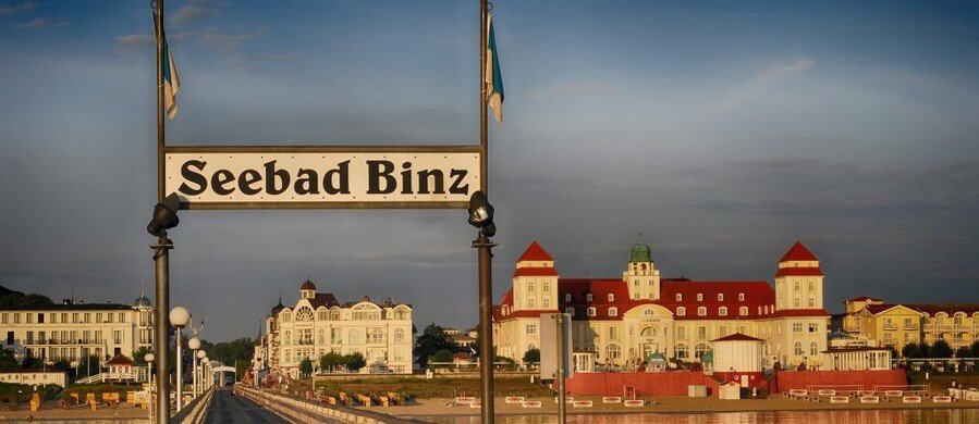 Seebad Binz sign on the pier with Kurhaus hotel at sunset in Binz Germany