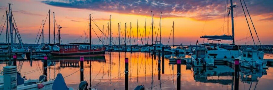 Glowe harbor on Rügen Island Germany with sailboats and sunset reflections on the Baltic Sea.