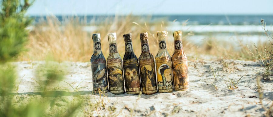 Rügener Insel-Brauerei craft beer bottles displayed on sandy Baltic beach on Rügen Island Germany.