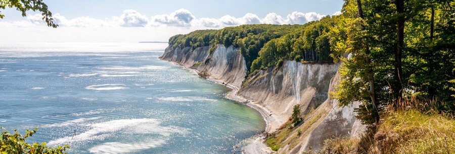 Chalk cliffs near Sellin on Rügen Island, Germany overlooking the Baltic Sea with forested coastline and turquoise water below.