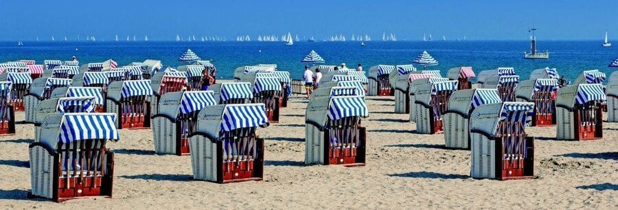 Traditional Strandkörbe beach baskets lined up on a sandy beach on Rügen Island Germany along the Baltic Sea
