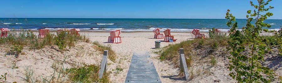 Thiessow Beach on Rügen Island Germany with sandy dunes wooden beach path and traditional Strandkorb chairs along the Baltic Sea