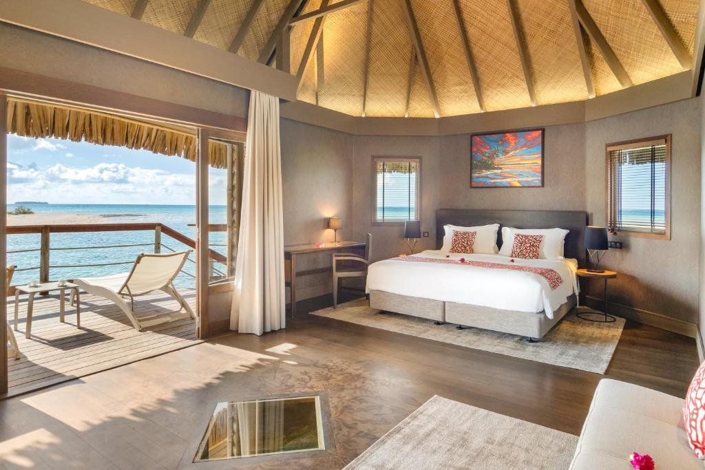 Overwater bungalow interior at Le Tikehau by Pearl Resorts with ocean view deck and glass floor panel