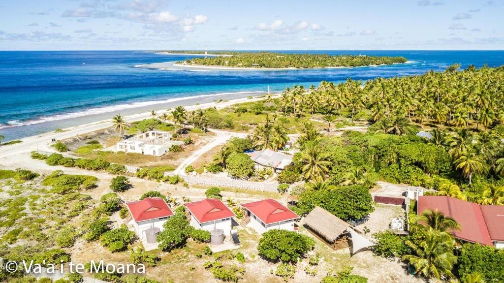Aerial view of Va’a i Te Moana with red-roof bungalows, palm trees, and turquoise lagoon in Rangiroa