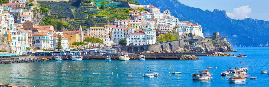 Colorful hillside town and boats in the harbor along the Amalfi Coast Italy