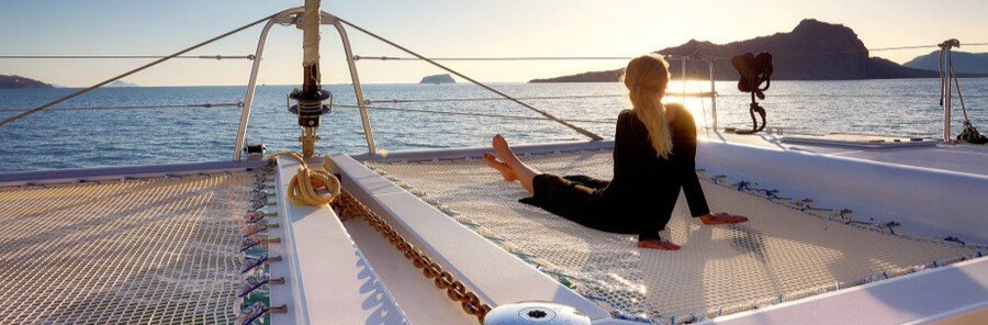 woman relaxing on catamaran during sunset cruise along Athens Riviera Greece
