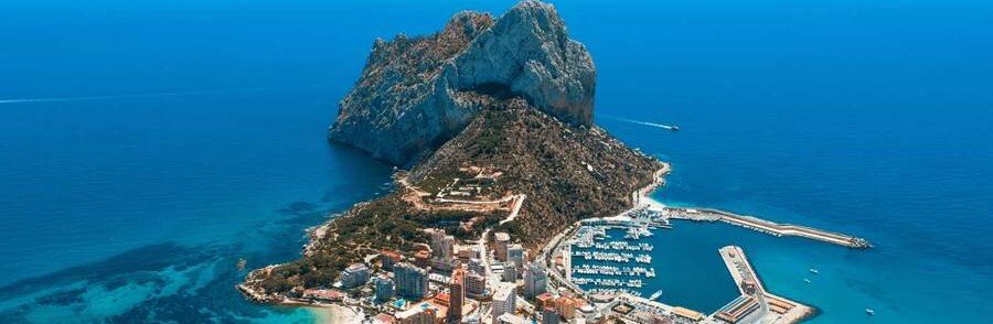 Aerial view of Penon de Ifach in Calpe Spain with marina, coastline, and turquoise Mediterranean Sea