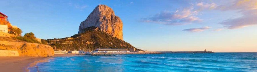 Golden sunset over Penon de Ifach and Calpe beach on the Costa Blanca with turquoise water and rocky coastline