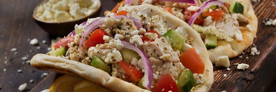 chicken souvlaki gyro with tzatziki sauce tomatoes cucumber and feta in pita