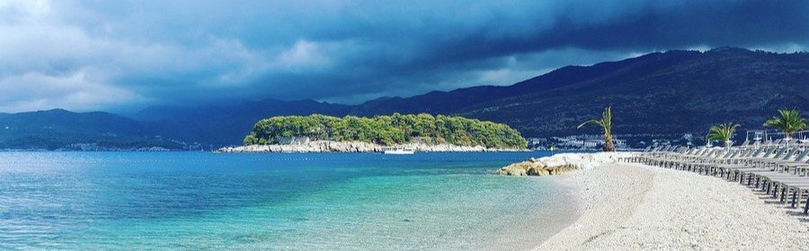 Copacabana Beach in Rio de Janeiro Brazil with turquoise water, sandy shoreline, and mountains in the background.