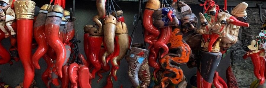 Traditional red cornicello lucky horn charms hanging in a Naples market Italy