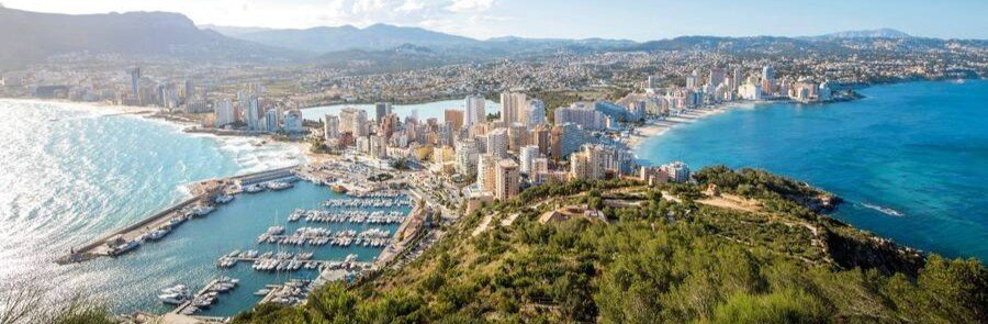 Aerial view of Costa Blanca city coastline with marina, beaches, and Mediterranean Sea in Spain