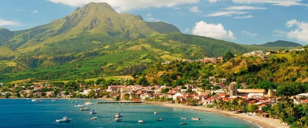 Fort-de-France bay in Martinique with colorful town, boats in the water, and lush green mountains in the background