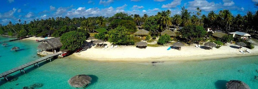Aerial view of Havaiki Lodge in Fakarava with beachfront bungalows, white sand, and clear lagoon water