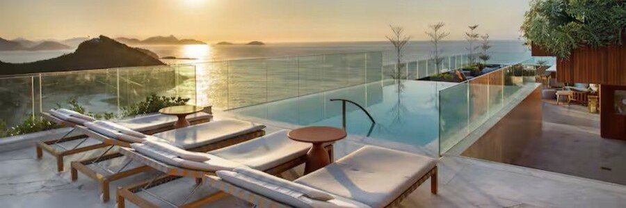 The luxury rooftop infinity pool at Hilton Rio de Janeiro Copacabana during a golden sunset over the ocean