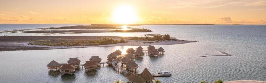 Overwater bungalows at Le Tikehau by Pearl Resorts during sunset in Tikehau French Polynesia