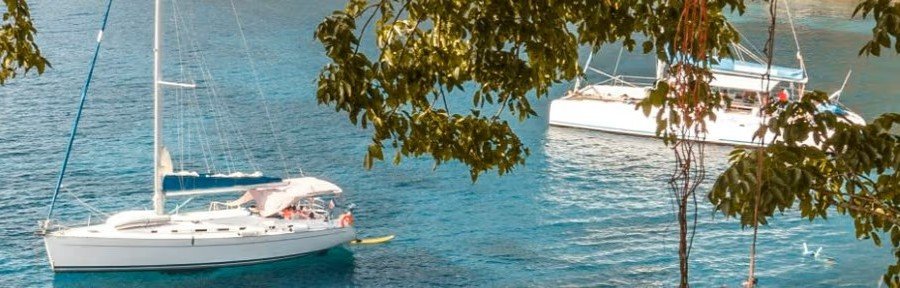 Catamarans anchored in calm coastal water with tropical scenery in Martinique