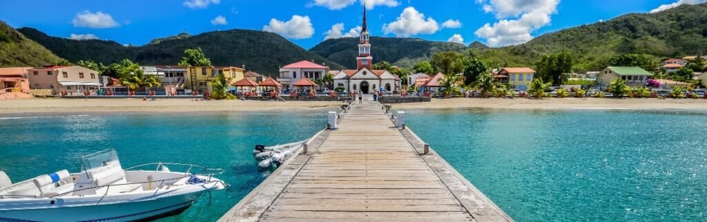 Pier leading to church and colorful buildings along waterfront Martinique