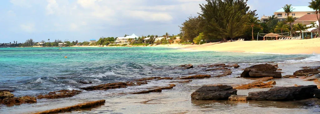Rocky shoreline with clear water and sandy beach in Martinique Caribbean