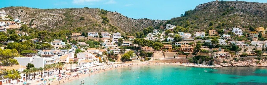 Moraira Spain beach with turquoise water, hillside homes, and sheltered cove on the Costa Blanca