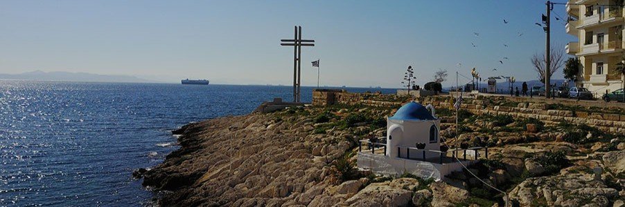 Piraiki coastal walkway with cross and seaside chapel in Piraeus Greece