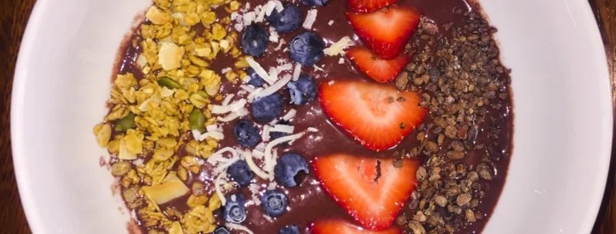 Acai bowl topped with strawberries, blueberries, granola, and coconut served in Rio de Janeiro Brazil.