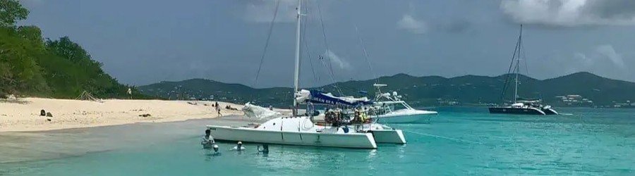 Catamaran anchored near Buck Island with people snorkeling in clear water St Croix US Virgin Islands