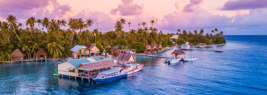 Overwater bungalows and boats at Tetamanu Village in Fakarava French Polynesia