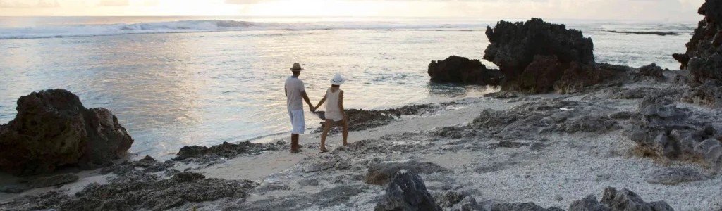 A peaceful sunset walk along the shoreline, where the lagoon meets coral and the day slows to a quiet close.