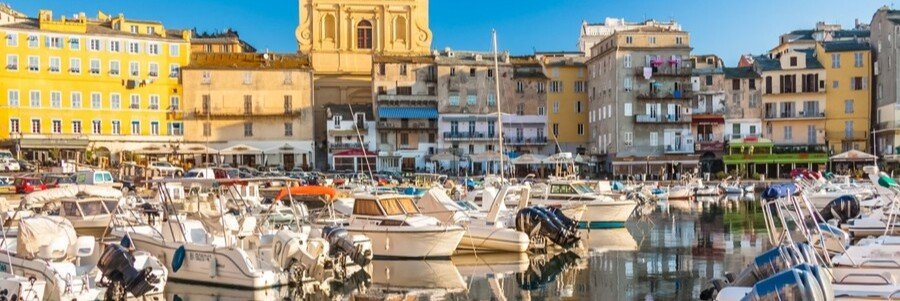 Bastia harbor in Corsica with boats docked in the marina and colorful old town buildings