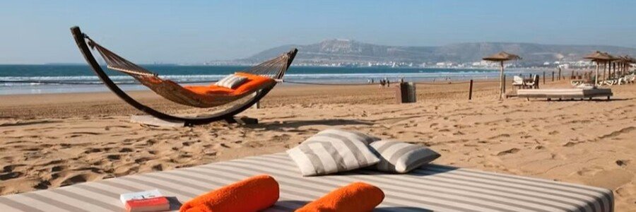 Relaxing beach scene in Agadir with loungers and ocean views.