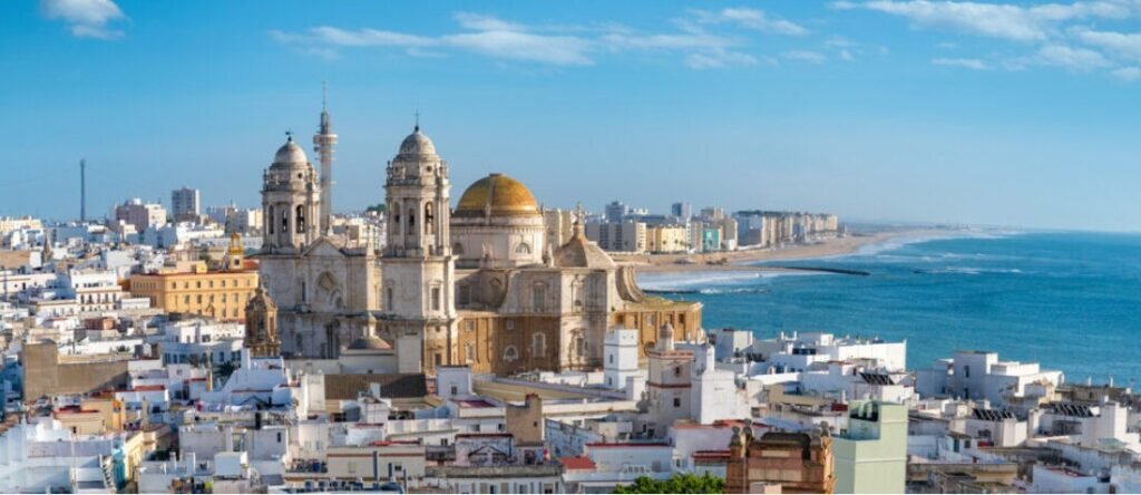 Cádiz cruise port view with cathedral, white buildings, and long sandy coastline