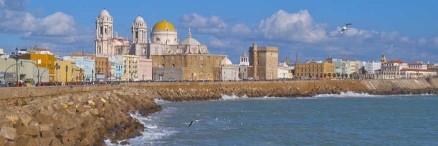 Cádiz Spain coastline with cathedral, ocean waves, and historic city walls