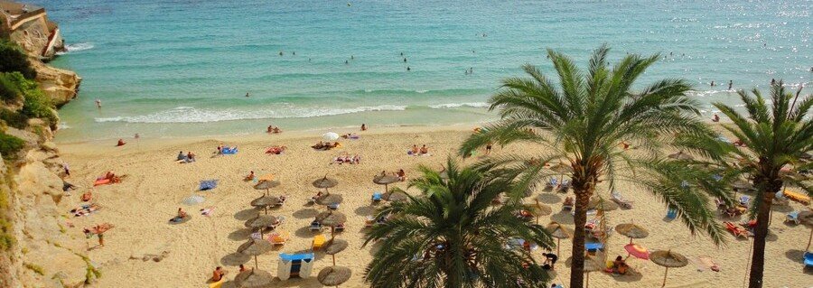 Cala Major Beach near Palma de Mallorca Port with golden sand, turquoise water, and palm trees