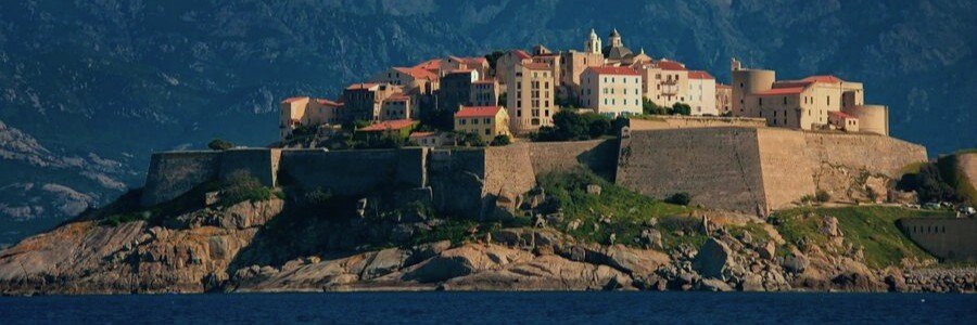Calvi Corsica citadel overlooking the sea with mountains in the background