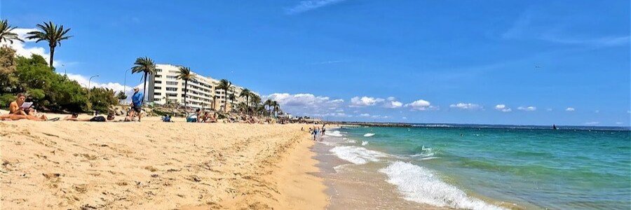 Can Pere Antoni Beach in Palma de Mallorca with city skyline and cathedral views along the shoreline