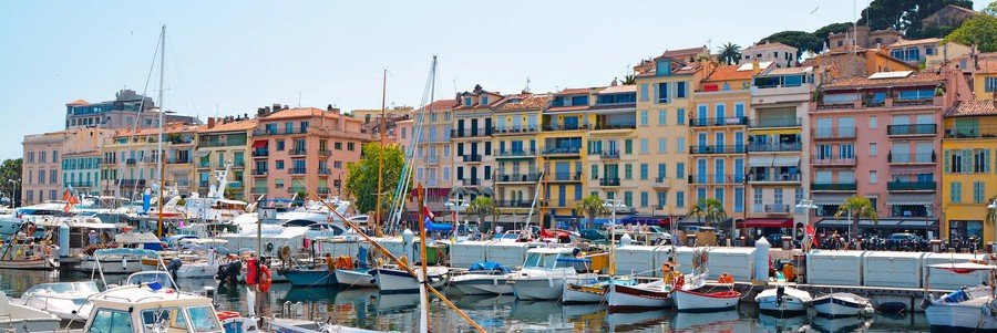 Cannes Port harbor with colorful buildings and boats along the waterfront