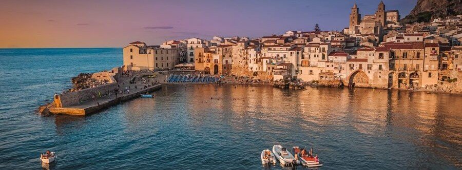 Coastal view of Cefalù Sicily with historic buildings along the shoreline