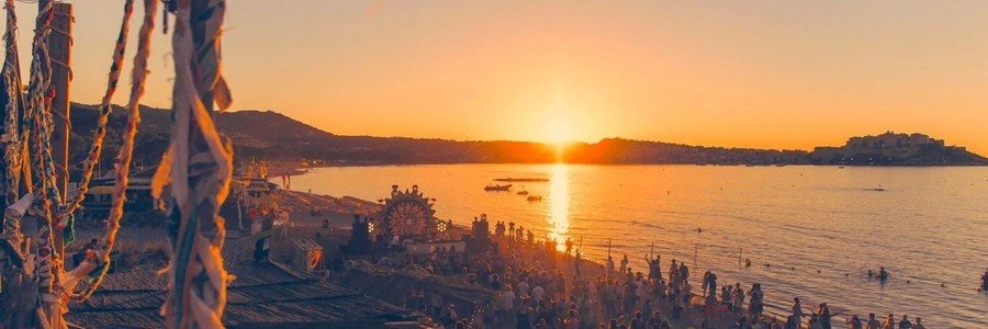 Corsica beach sunset with crowd enjoying seaside festival and golden light reflecting on the water